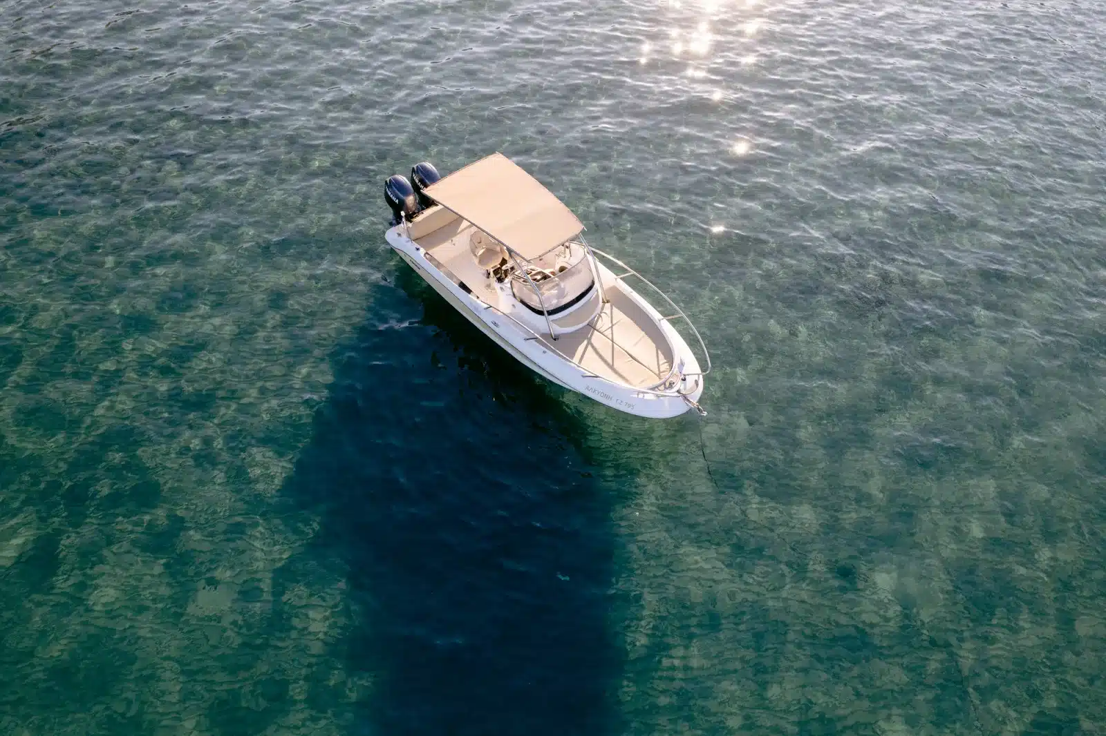 Featured private charter boat floating over crystal-clear Ionian water