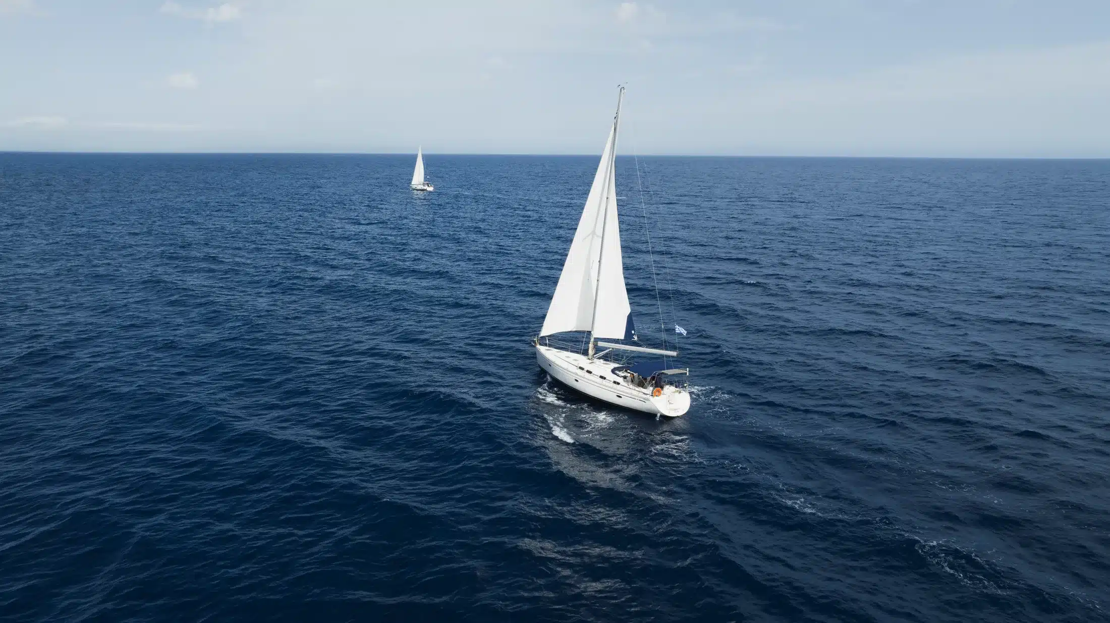Drone aerial of two Ioneon Travel sailing yachts cruising off Zakynthos